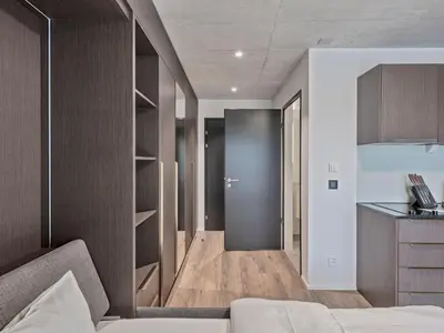a room with a bed and a hallway with shelves at MOOI Apartments St.Gallen in St. Gallen