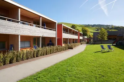 a row of chairs on a lawn next to a building at Reka-Feriendorf Urnäsch in Urnäsch