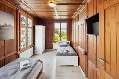 a room with two beds and a television in it at FENUS Apartment mit traumhaftem Bergblick SGT02 in Grabs