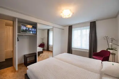 a hotel room with a white bed and a tv at Gasthaus zum Bahnhof in Berg