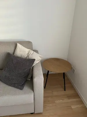 a living room with a couch and a wooden table at Black&White Apartment in Uzwil