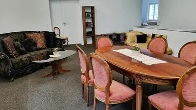 a living room with a wooden table and chairs at Treffpunkt Heuwiese in Weite