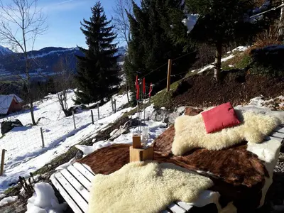 two sheep on a snow covered hill with a bench at IB Säntis Chalet Chnorz Apartment in Nesslau