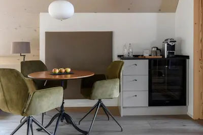 a kitchen with a table and chairs in a room at Dorfhus Gupf in Rehetobel