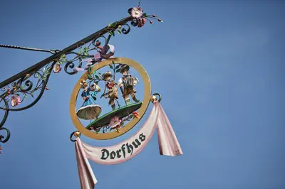 a sign for a disney store hanging on a tree at Dorfhus Gupf in Rehetobel