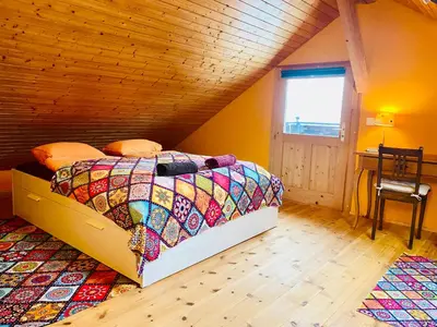 a bedroom with a bed with a colorful quilt at Birkenhof, Haus Schwänli in Herisau