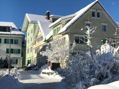 a building with snow on the ground in front of it at Bijou 1 Hübsche 1 Zimmer Wohnung in Herisau