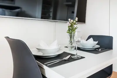 a white table with a vase of flowers on it at SOHO 3B !Gratis Parken, Free Parking! in Kreuzlingen