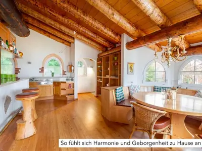 a kitchen with wooden ceilings and a table and chairs at Chalet Müsli in Wildhaus