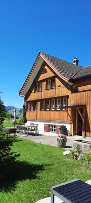 a large wooden building with a picnic table in front of it at Ferienhaus Rütiweid in Appenzell