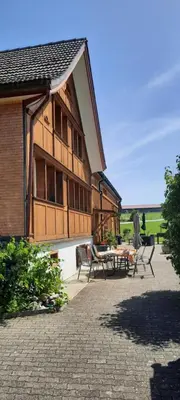 a house with a table and chairs in front of it at Ferienhaus Rütiweid in Appenzell