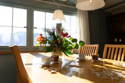a dining room table with a vase of flowers on it at Undereggli in Nesslau