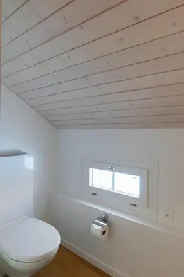 a bathroom with a white toilet and a window at Undereggli in Nesslau