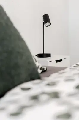 a lamp sitting on a table next to a bed at Dein Zuhause in Herisau in Herisau