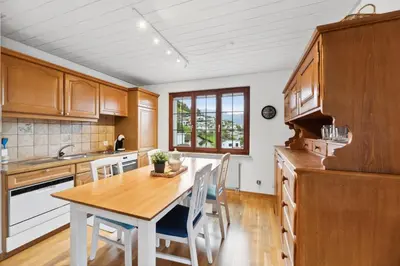 a kitchen with wooden cabinets and a table and chairs at Sonniges Apartment mit traumhaftem Bergblick in Buchs