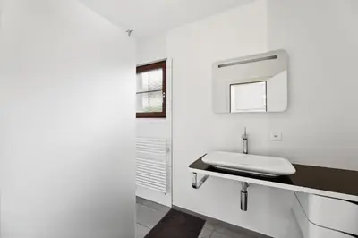 a white bathroom with a sink and a mirror at Sonniges Apartment mit traumhaftem Bergblick in Buchs
