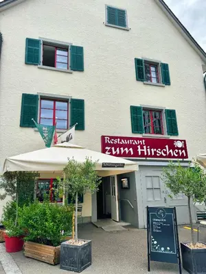 a restaurant with a sign in front of a building at tas24ch Travel and Sleep 24 in St. Gallen