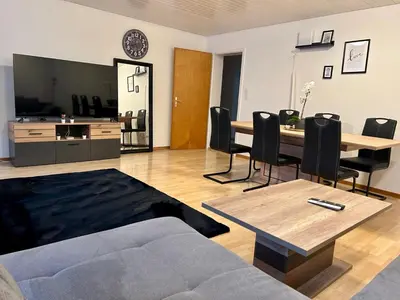 a living room with a couch and a table and chairs at tas24ch Travel and Sleep 24 in St. Gallen
