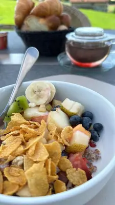 a bowl of food with fruit and chips and bread at Hotel Säntis Teufen in Teufen