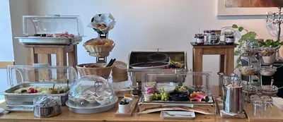 a table topped with glass containers filled with food at Hotel Säntis Teufen in Teufen