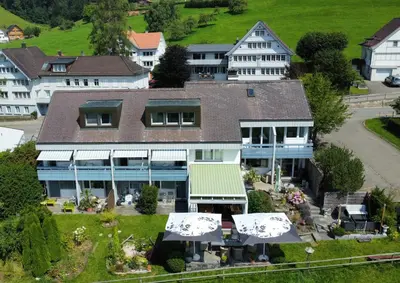 an aerial view of a large house with umbrellas at Hotel Säntis Teufen in Teufen