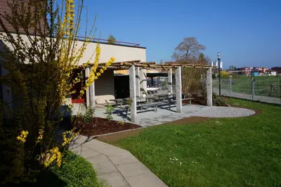 a garden with a picnic table and a pergola at Jugendherberge Romanshorn in Romanshorn