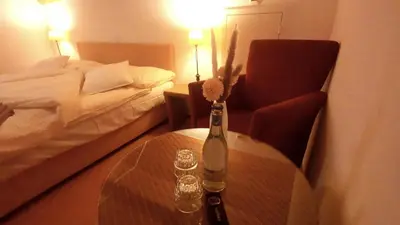 a room with a table with a bottle and a bed at il fiore Hotel Steinach SG in Steinach