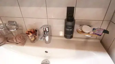 a bathroom sink with a bottle of alcohol on it at il fiore Hotel Steinach SG in Steinach