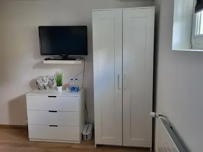 a white cabinet with a television on top of it at Ahornwohnung, ruhige Lage, nähe Bahnhof und Zentrum in Buchs