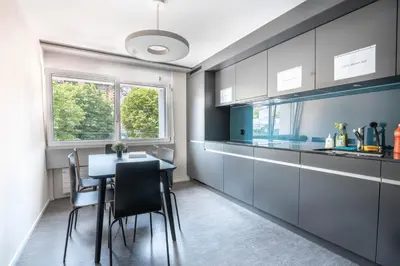 a kitchen with a table and chairs in a room at INN JOY Apartments - Sankt Gallen Center in St. Gallen