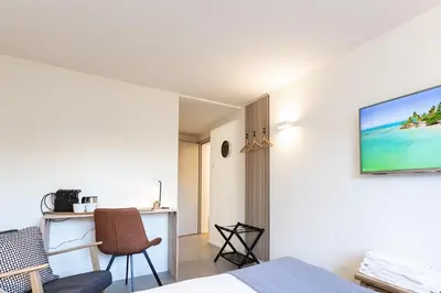 a bedroom with a bed and a tv on a wall at INN JOY Apartments - Sankt Gallen Center in St. Gallen