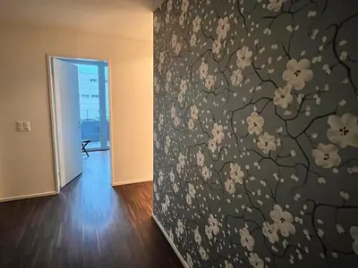 a room with a wall with a floral wallpaper at Deluxe Zimmer in Privatwohnung an zentraler Lage in Teufen