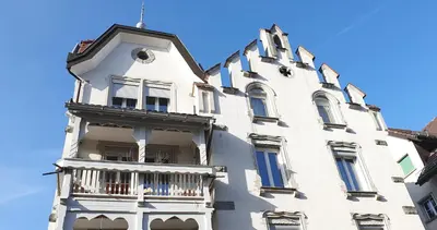 a white building with a balcony on the side of it at 2-4 Zimmer Apartments Stilvoll im Gertrud Schlössli - zentral ruhig in St. Gallen