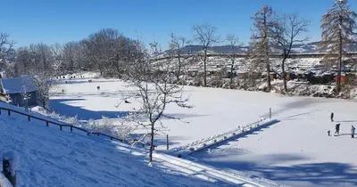 a snow covered slope with people skiing in the distance at 2-4 Zimmer Apartments Stilvoll im Gertrud Schlössli - zentral ruhig in St. Gallen