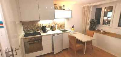 a kitchen with white cabinets and a table and a sink at Stilvoll Gertrud Schlössli 1 Zi Studio in St. Gallen