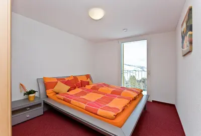 a bedroom with a bed and a large window at Berggasthaus Oberdorf in Wildhaus