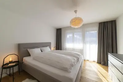 a bedroom with a large bed and a large window at Gamsalpblick in Wildhaus