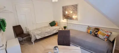 a bedroom with a bed and a desk and a table at 2 Zimmer Zentral-ruhig mit Flair Gertrud Schlössli 3Z2 in St. Gallen