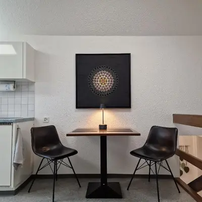 a patio with two chairs and a table at peaceful tiny house near forest in Rorschacherberg