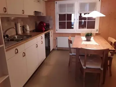 a kitchen with a wooden table and a dining room at Zwinglis Ferienwohnung Rosi in Nesslau