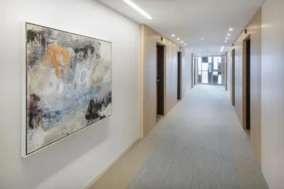 a hallway in a building with a painting on the wall at Newstar Hotel (Free Parking) in St. Gallen