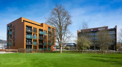 a large building with a grass field in front of it at Newstar Hotel (Free Parking) in St. Gallen