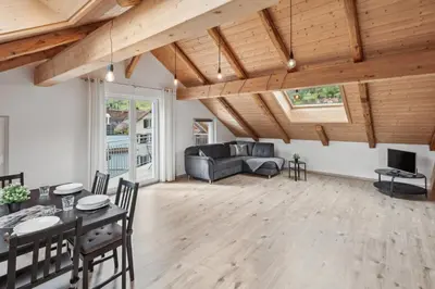 a living room with wooden ceilings and a table and chairs at FENUS Grabs Gemütliche Ferienwohnung SGT06 in Grabs