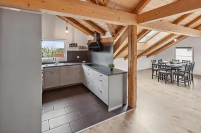 a kitchen with wooden ceilings and a dining room with a table at FENUS Grabs Gemütliche Ferienwohnung SGT06 in Grabs