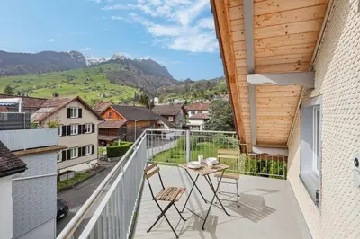 a balcony with a table and chairs and a view at FENUS Grabs Gemütliche Ferienwohnung SGT06 in Grabs