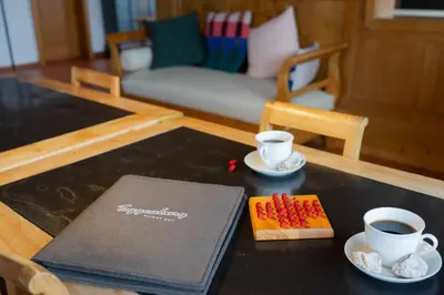 a table with two cups of coffee and a book at Chammern in Nesslau