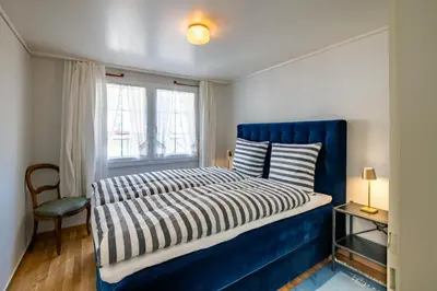 a bedroom with a blue bed and a window at Blattenheimat6 - im traditionellen Appenzeller Haus in Appenzell