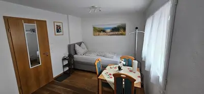 a small room with a small bed and a table at Private Etage 5 Min vom Bahnhof - Parken - Küche - Netflix in Widnau