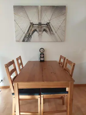 a wooden table with two chairs and a clock at Global Citizen 5 in St. Gallen