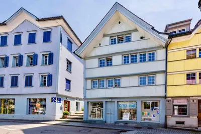 a group of three buildings next to each other at Farbige Wohnung Zentral in Herisau